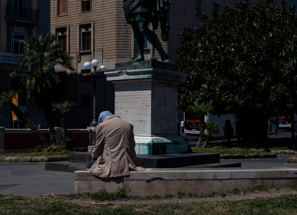 Italien assis sur un banc face à une statue
